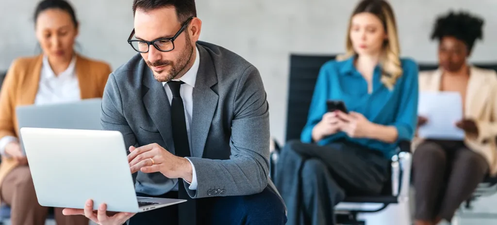 社員たちがそれぞれ席に座り持っているデバイスを眺めている